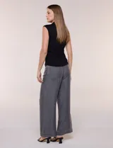 Musculosa negra de modal, con cuello alto, sin mangas y frunces drapeados en los laterales de la cintura.