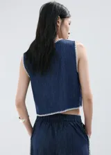 Top de algodón estilo denim, de corte recto y sin mangas con tirantes anchos, cuello redondo y detalle de ribetes contrastantes con costuras decorativas blancas en los bordes.