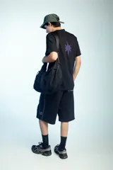 Bolso impermeable negro de gran capacidad confeccionado en nylon de alta densidad, con recubrimiento interno plástico, correa ajustable y bolsillos externos e internos con cierre.