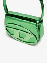 Bolso compacto tipo bandolera para mujer, con asa corta para llevar al hombro y correa desmontable opcional para usar cruzado. Confeccionado en cuero con acabado espejado brillante color morado. Presenta placa oval D galvanizada en la solapa.