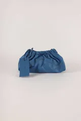 Cartera tipo sobre de cuero verde, con diseño fruncido y correa ajustable.