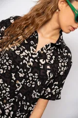 Vestido camisero midi negro con estampado floral blanco, de corte recto y manga corta.