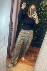 Pantalón de corte recto con estampado animal print en tonos beige y gris. Presenta cintura elástica y diseño holgado.