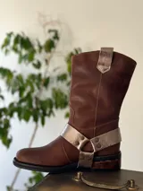 Bota de cuero marrón con estribo desmontable plateado.