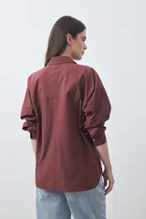 Camisa de manga larga de algodón en color blanco, con cuello clásico, cierre frontal de botones y silueta relajada.