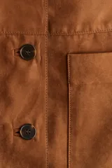 Campera marrón de tejido suave con acabado cepillado, estilo chaqueta o saco. Presenta solapas de muesca, cierre frontal de tres botones y dos bolsillos parche grandes en la parte delantera inferior.