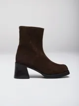 Bota de caña media con punta cuadrada, confeccionada en cuero gamuzado color marrón, con taco bloque y suela de goma negra.
