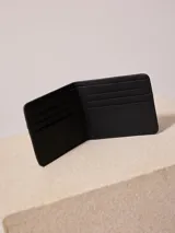 Billetera plegable color negro, con compartimentos internos.
