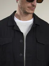 Campera tipo overshirt color azul marino, con cuello clásico, cierre frontal con botones, cuatro bolsillos frontales con solapa y puños abotonados.