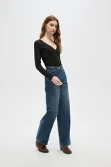 Pantalon de jean de corte recto y tiro medio, con diseño de cinco bolsillos y cierre frontal con botón y cremallera.