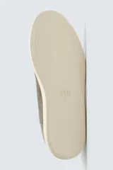 Zapatilla urbana de hombre confeccionada en piel con acabado de serraje, diseño minimalista con cordonera oculta y suela de goma a contraste.