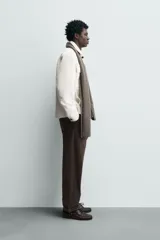 Sobrecamisa regular fit color verde oscuro, confeccionada en tejido efecto ante. Cuenta con cuello solapa, manga larga con puño abotonado, bolsillos de plastrón con solapa en el pecho y bolsillos de vivo en la cadera. El cierre es frontal con botonadura.