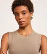 Blusa sin mangas color beige confeccionada en tejido de punto con textura acanalada y cuello redondo.