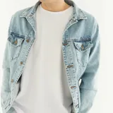 Campera de jean celeste claro con cuello clásico, cierre frontal con botones metálicos, bolsillos con solapa abotonada en el pecho y bolsillos laterales.