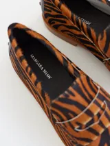Mocasines de cuero con estampado animal print de tigre en tonos marrones y negros. Diseñados en Uruguay y producidos en Brasil.