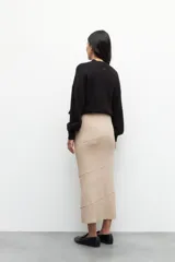 Falda larga de punto color negro, de corte ajustado al cuerpo, con diseño de costuras horizontales y diagonales que crean un efecto de paneles.