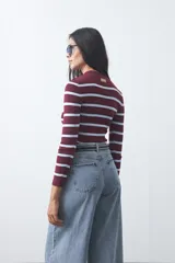 Polera de tejido rib al cuerpo con diseño de rayas horizontales en color bordó y celeste, cuello alto y manga larga.