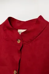 Vestido camisero corto color fucsia, confeccionado en lino imperial con botones de guampa y detalle de simil cuero calado en las mangas.