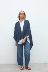 Ruana de punto azul marino, de diseño abierto y corte amplio y fluido.