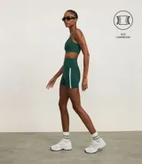 Bermuda deportiva de alta compresión, color verde oscuro, con cintura ancha doblada y detalle de bies lateral en color blanco.