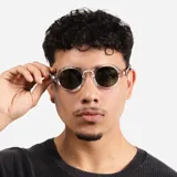 Lentes de sol con armazón redondo de acetato transparente y cristales oscuros con protección UV400.