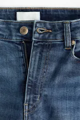 Jean skinny de tiro alto en denim azul con efecto deslavado y leve elasticidad, corte ajustado de cadera a tobillo, con diseño clásico de cinco bolsillos y cierre frontal con botón y cremallera.
