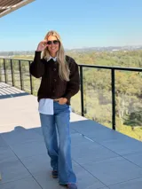 Saco de punto color chocolate con diseño de tejido acanalado, cuello redondo, cierre frontal con botones grandes y mangas globo con puños ajustados.