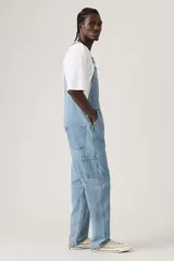 Jardinera de jean en corte holgado, con tirantes ajustables, múltiples bolsillos funcionales y cierre de botones laterales.