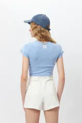 Top corto negro ajustado al cuerpo, de manga corta y cuello redondo.