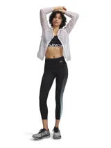 Calza deportiva de corte tobillero con tecnología HeatGear, diseñada para ofrecer alta transpirabilidad y secado rápido. Presenta un diseño bicolor con paneles laterales en degradado de gris a celeste, cintura elástica de tiro alto con cordón interno, bolsillos laterales y detalles reflectantes.