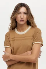 Vestido midi de tejido de punto color camel, con escote redondo, mangas cortas, tajos laterales y detalles de tramas caladas y rayas blancas en el cuello, mangas y ruedo.