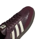 Championes Adidas Samba OG de color bordó con textura símil piel de serpiente y detalles en blanco marfil. Cuentan con las clásicas tres tiras laterales, inscripción 'SAMBA' en letras doradas, refuerzo de gamuza en la puntera y suela de goma marrón.