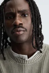 Jersey de corte relajado confeccionado en tejido de algodón con textura de canalé. Presenta cuello redondo, manga larga y un acabado con efecto lavado, con terminaciones en rib en cuello, puños y bajo.