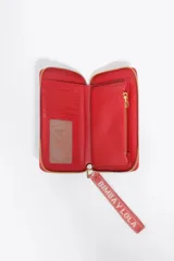 Billetera mediana de estructura rígida confeccionada en piel vacuna negra, con cierre de cremallera, tirador de tejido con logo y logo metálico frontal.