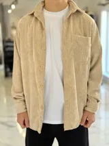 Sobrecamisa de pana color beige, de manga larga, con cuello clásico, cierre frontal de botones y un bolsillo aplicado en el pecho.