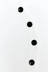 Chaqueta de punto de cuello redondo y manga larga, en color blanco, con cierre frontal asimétrico de botones negros.