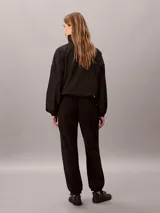 Jogger Calvin Klein de tejido polar color negro, con corte regular, cintura elástica con cordón ajustable y puños elásticos en los tobillos.