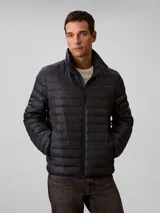 Campera puffer ligera de Calvin Klein, color azul marino, con diseño de acolchado horizontal, cuello alto y cierre frontal de cremallera.