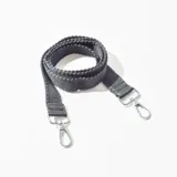 Correa de tela negra con mosquetones metálicos plateados en los extremos.