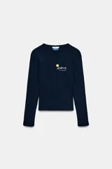 Camiseta de manga larga y cuello redondo, confeccionada en algodón. Presenta un diseño ajustado con detalle de texto y gráfico bordado en el pecho a contraste.