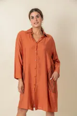 Túnica marrón de viscosa texturizada con cierre de botones, bolsillos laterales y detalle de rayas verticales en los bolsillos.