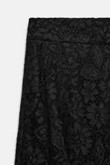 Pantalón de tiro alto confeccionado en encaje negro con diseño floral, de corte recto y largo cropped. Cuenta con forro interior a tono y cierre frontal con cremallera y ganchos metálicos.