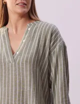 Blusa verde con rayas verticales blancas, cuello en V con botones y mangas 3/4 con puño y botón.