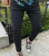 Pantalón chupín de jean negro, de corte ajustado y diseño liso.