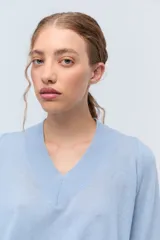 Sweater de tejido de punto color beige, con escote en V y calce holgado.