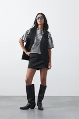 Short pollera de tiro medio y silueta recta, con diseño frontal tipo falda y estructura interna de short.