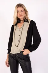 Camisa de crepe negra con detalle en la parte frontal de seda color habano y vivo dorado. Cierre mediante botones en el frente y cuello camisero.