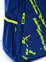 Mochila azul marino con diseño gráfico de salpicaduras en verde lima y letras blancas y verdes que forman la palabra "Umbro" verticalmente. Incluye el logo de Umbro en la parte superior central.