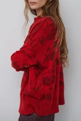 Buzo de tejido de punto con cuello redondo, mangas largas con puños acanalados y diseño estampado de flores en tonos rojos.