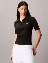 Chomba de Calvin Klein Jeans confeccionada en tejido de algodón con elastano, de corte regular y textura acanalada. Presenta cuello tipo polo con cartera de dos botones, mangas cortas e insignia de la marca en el pecho.